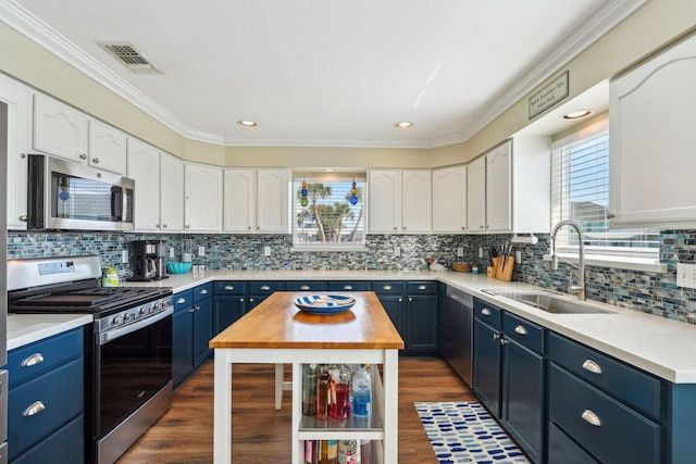 22123 Yoakum Dr, Galveston, TX 77554 - kitchen featuring blue cabinets, stainless steel appliances, wood counters, white cabinets, and crown molding