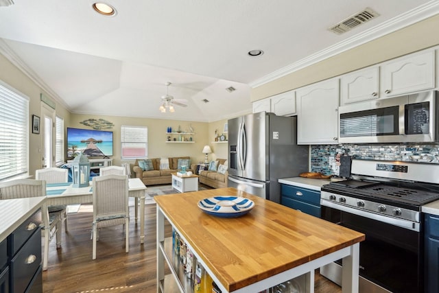 22123 Yoakum Dr, Galveston, TX 77554 - kitchen featuring stainless steel appliances, white cabinets, a ceiling fan, dark wood-style floors, and crown molding