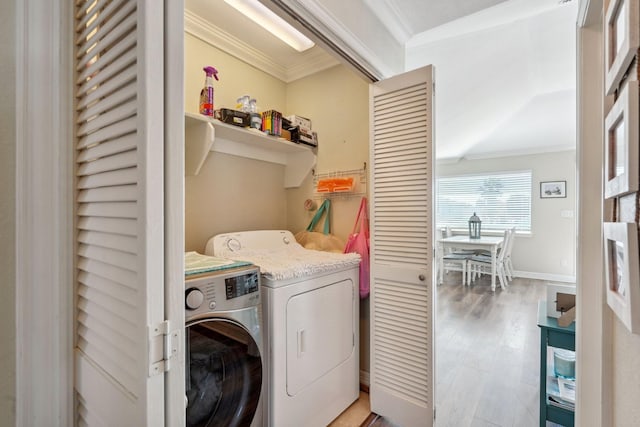 22123 Yoakum Dr, Galveston, TX 77554 - laundry room with washing machine and dryer, ornamental molding, and light wood-style floors