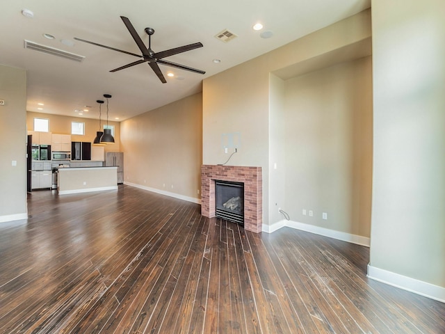 3419 Gillespie St, Houston, TX 77020 - unfurnished living room featuring dark wood finished floors, ceiling fan, a fireplace, and recessed lighting
