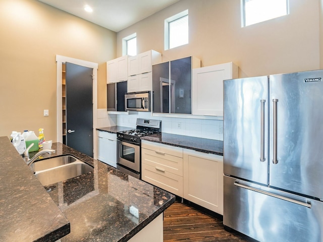 3419 Gillespie St, Houston, TX 77020 - kitchen with appliances with stainless steel finishes, decorative backsplash, dark wood-style flooring, white cabinets, and a towering ceiling