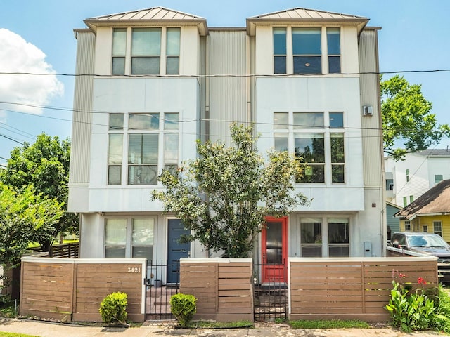 3419 Gillespie St, Houston, TX 77020 - view of front of home with a standing seam roof, a gate, and stucco siding