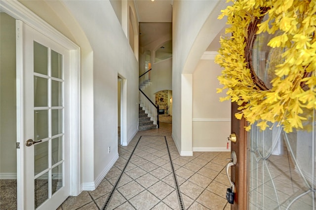 30 N Scribewood Cir, The Woodlands, TX 77382 - foyer entrance with arched walkways, stairs, light tile patterned floors, and a towering ceiling