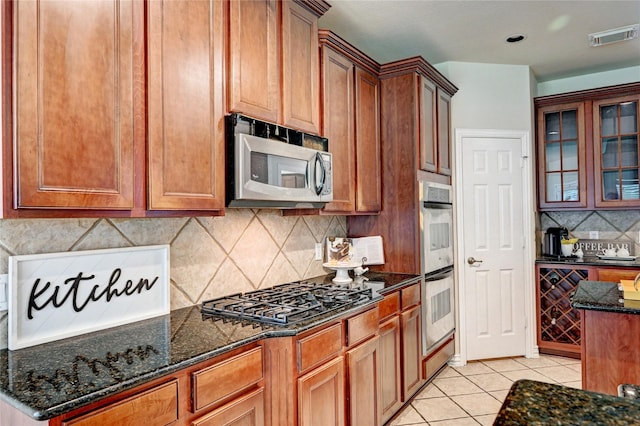 30 N Scribewood Cir, The Woodlands, TX 77382 - kitchen featuring stainless steel appliances, light tile patterned flooring, beverage cooler, backsplash, and glass insert cabinets