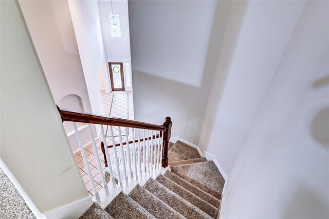 30 N Scribewood Cir, The Woodlands, TX 77382 - stairs featuring baseboards and a towering ceiling