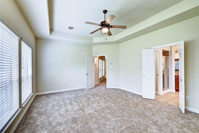 30 N Scribewood Cir, The Woodlands, TX 77382 - unfurnished bedroom with carpet floors, a tray ceiling, and ceiling fan