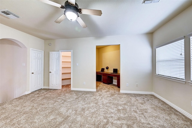 30 N Scribewood Cir, The Woodlands, TX 77382 - unfurnished bedroom featuring a walk in closet, carpet flooring, arched walkways, ensuite bath, and an office area