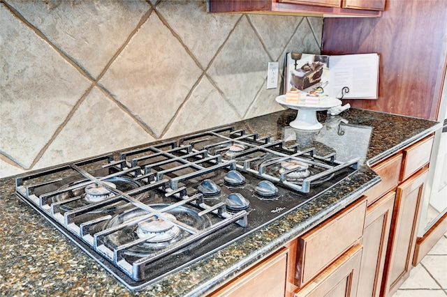30 N Scribewood Cir, The Woodlands, TX 77382 - kitchen view of black gas cooktop, tasteful backsplash, and dark stone counters