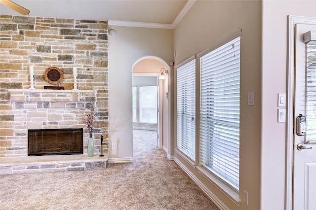 30 N Scribewood Cir, The Woodlands, TX 77382 - unfurnished living room featuring carpet, crown molding, arched walkways, and a fireplace
