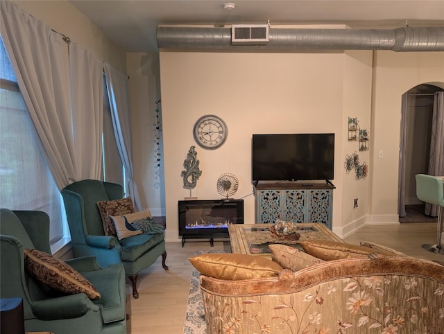 1901 Post Oak Blvd Unit 3101, Houston, TX 77056 - living area featuring arched walkways, wood finished floors, and a glass covered fireplace