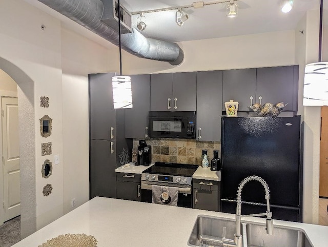 1901 Post Oak Blvd Unit 3101, Houston, TX 77056 - kitchen featuring black appliances, decorative backsplash, arched walkways, light countertops, and decorative light fixtures