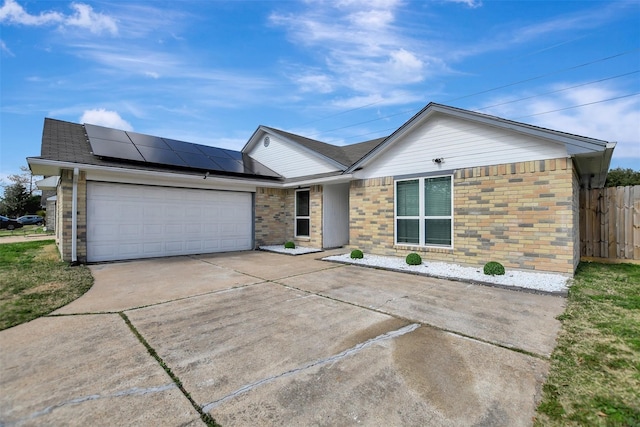 16806 Carbridge Dr, Houston, TX 77084 - ranch-style home with driveway, a garage, roof mounted solar panels, brick siding, and a shingled roof