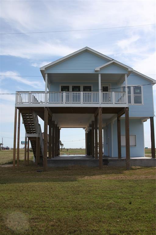 13214 Buccaneer Pkwy, Freeport, TX 77541 - rear view of house featuring stairs, a yard, and a deck