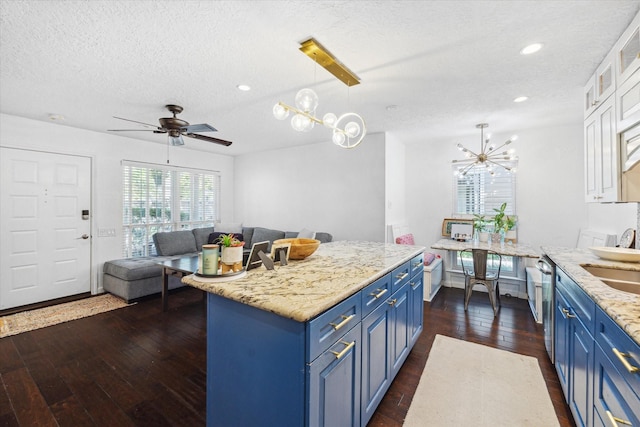 1880 White Oak Dr Unit 159, Houston, TX 77009 - kitchen featuring blue cabinetry, a textured ceiling, a chandelier, dark wood-type flooring, and open floor plan