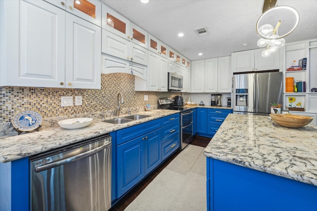 1880 White Oak Dr Unit 159, Houston, TX 77009 - kitchen featuring stainless steel appliances, blue cabinets, white cabinets, decorative backsplash, and recessed lighting