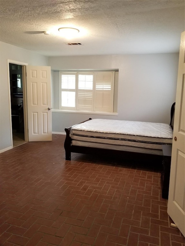 8806 Leader St, Houston, TX 77036 - bedroom featuring brick floors and a textured ceiling
