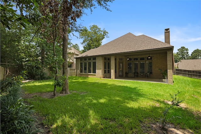 131 Evening Tide Ct, Conroe, TX 77318 - rear view of house featuring brick siding, a fenced backyard, a shingled roof, a chimney, and a patio