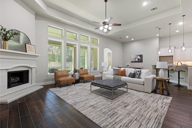 131 Evening Tide Ct, Conroe, TX 77318 - living room with dark wood finished floors, a tray ceiling, recessed lighting, a fireplace, and a ceiling fan