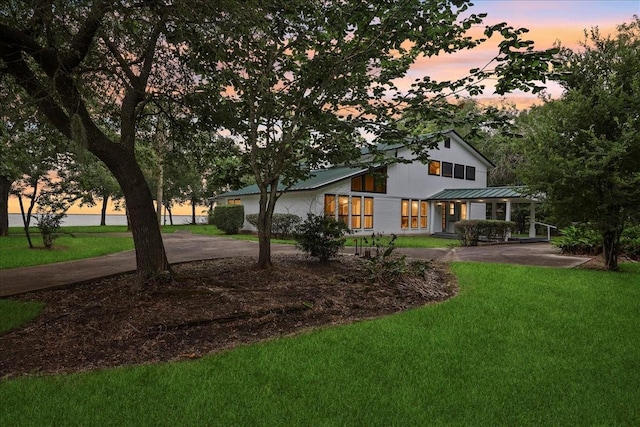 3533 Fm 563, Anahuac, TX 77514 - back of property at dusk featuring a yard, a metal roof, and a standing seam roof