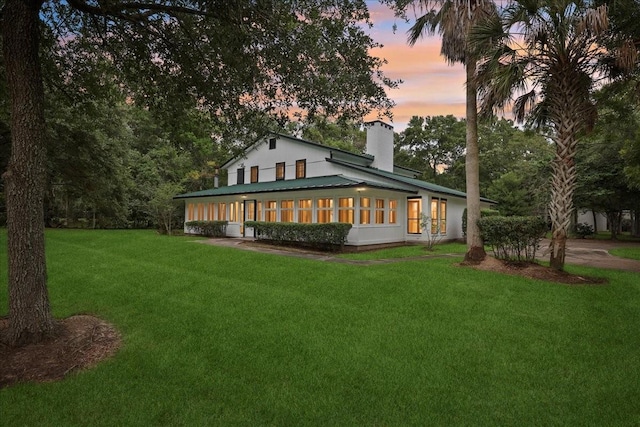 3533 Fm 563, Anahuac, TX 77514 - back of property at dusk featuring a chimney and a yard