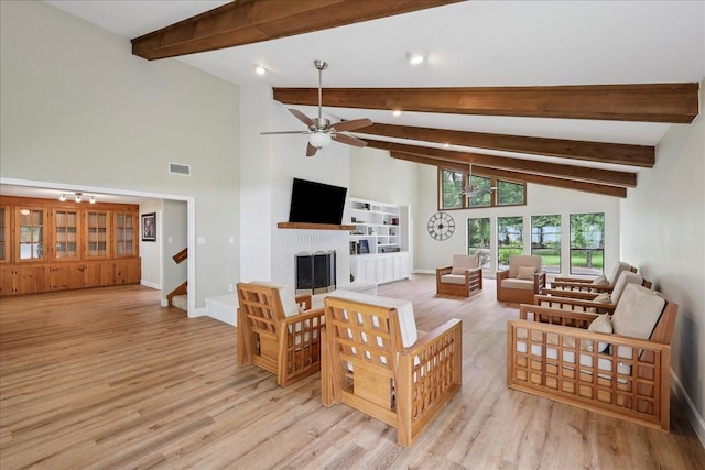 3533 Fm 563, Anahuac, TX 77514 - living room with a fireplace, light wood-type flooring, beamed ceiling, ceiling fan, and stairs