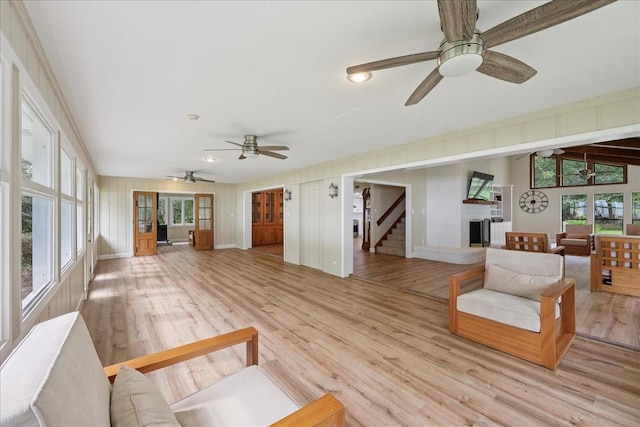 3533 Fm 563, Anahuac, TX 77514 - living room featuring a ceiling fan, healthy amount of natural light, light wood finished floors, and stairway