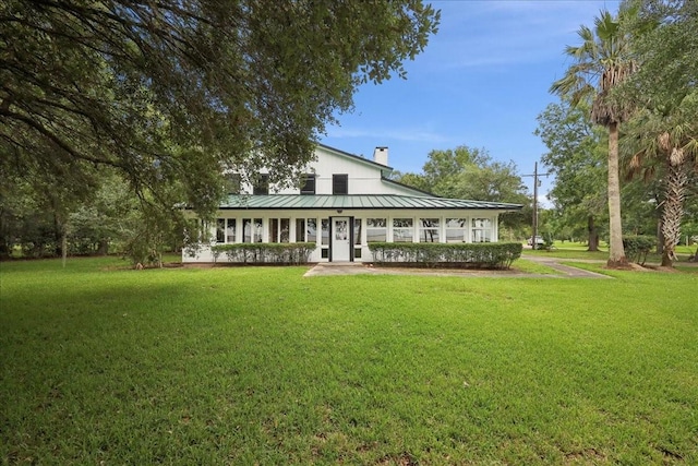 3533 Fm 563, Anahuac, TX 77514 - rear view of house with a chimney, a yard, a standing seam roof, and a metal roof