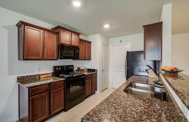 22418 Threefold Ridge Dr, Hockley, TX 77447 - kitchen featuring black appliances, dark stone counters, light tile patterned floors, and recessed lighting