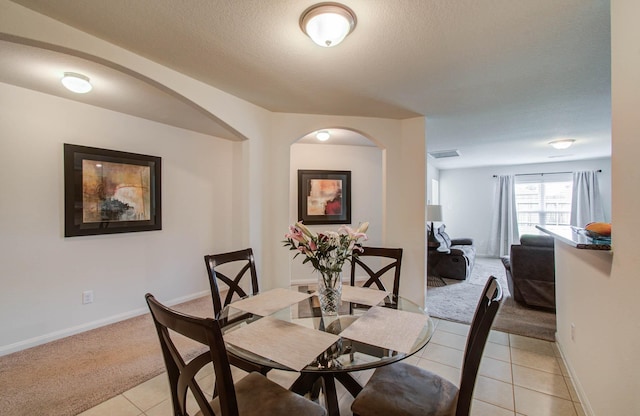 22418 Threefold Ridge Dr, Hockley, TX 77447 - dining area with light colored carpet, light tile patterned floors, arched walkways, and a textured ceiling