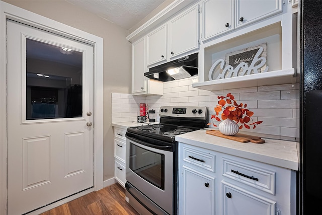 5130 Porter Ridge Dr, Houston, TX 77053 - kitchen with stainless steel electric range oven, under cabinet range hood, wood finished floors, white cabinets, and decorative backsplash