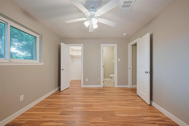 5130 Porter Ridge Dr, Houston, TX 77053 - unfurnished bedroom featuring light wood-type flooring, a spacious closet, a ceiling fan, a closet, and ensuite bath