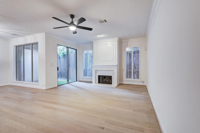 2308 Nantucket Dr Unit B, Houston, TX 77057 - unfurnished living room with crown molding, a fireplace, light wood-type flooring, ceiling fan, and a textured ceiling