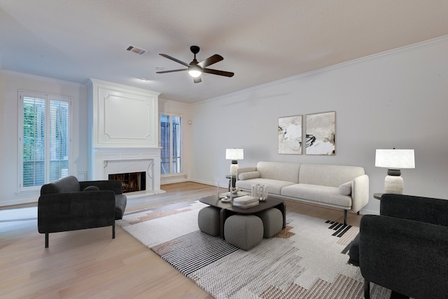 2308 Nantucket Dr Unit B, Houston, TX 77057 - living room with light wood-style floors, ornamental molding, a ceiling fan, and a fireplace