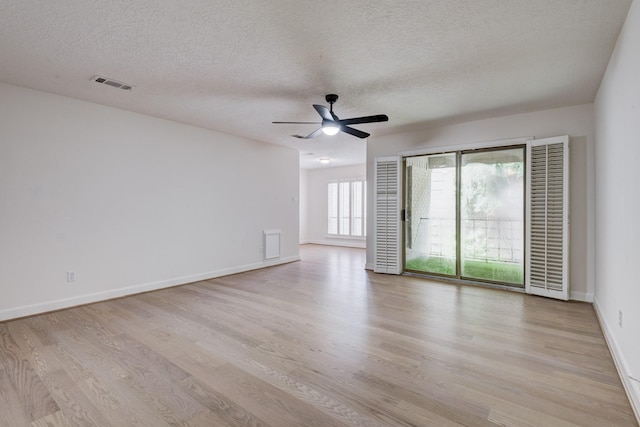 2308 Nantucket Dr Unit B, Houston, TX 77057 - empty room with light wood-type flooring, a textured ceiling, a ceiling fan, and a heating unit