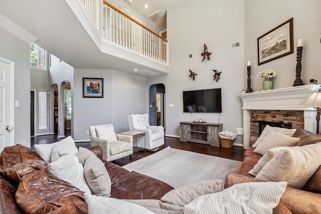 13518 Via Chianti Ln, Cypress, TX 77429 - living room with arched walkways, a towering ceiling, wood finished floors, and a stone fireplace