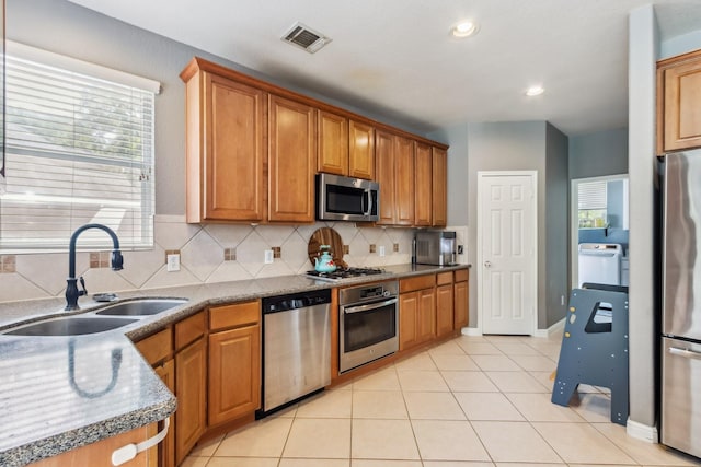 13518 Via Chianti Ln, Cypress, TX 77429 - kitchen with stainless steel appliances, washer / clothes dryer, backsplash, light tile patterned flooring, and recessed lighting