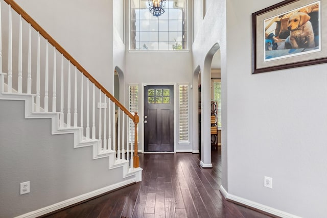 13518 Via Chianti Ln, Cypress, TX 77429 - foyer entrance with arched walkways, dark wood-type flooring, a towering ceiling, stairs, and a chandelier