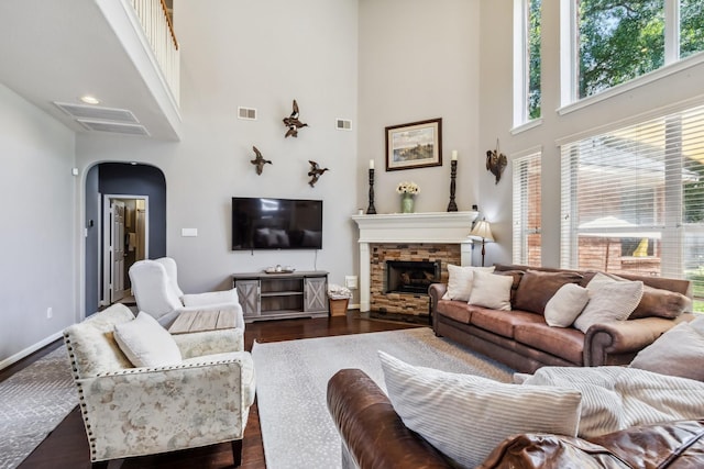 13518 Via Chianti Ln, Cypress, TX 77429 - living area featuring a towering ceiling, arched walkways, dark wood-type flooring, and a stone fireplace