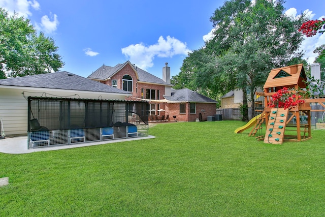 13518 Via Chianti Ln, Cypress, TX 77429 - back of house featuring a playground, a shingled roof, a patio, and brick siding
