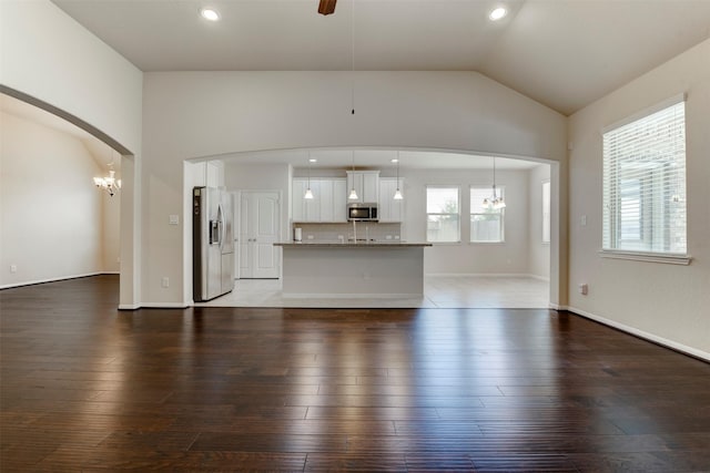 24014 Bluestem Ridge Ct, Katy, TX 77493 - unfurnished living room with lofted ceiling, a chandelier, arched walkways, hardwood / wood-style flooring, and recessed lighting