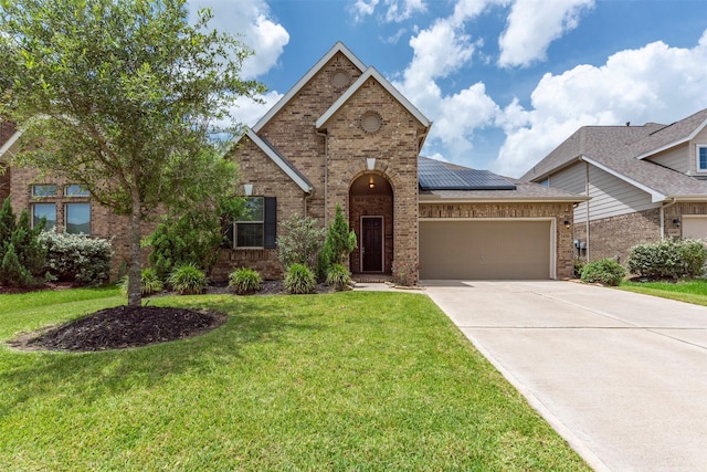 24014 Bluestem Ridge Ct, Katy, TX 77493 - view of front of house with brick siding, a garage, solar panels, concrete driveway, and a front yard