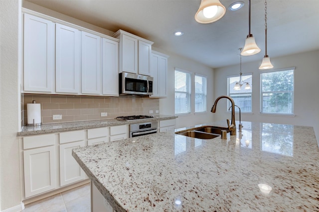 24014 Bluestem Ridge Ct, Katy, TX 77493 - kitchen featuring stainless steel appliances, white cabinetry, backsplash, light stone counters, and recessed lighting