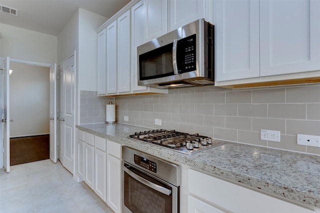 24014 Bluestem Ridge Ct, Katy, TX 77493 - kitchen featuring stainless steel appliances, white cabinets, decorative backsplash, and light stone countertops