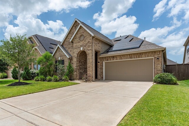 24014 Bluestem Ridge Ct, Katy, TX 77493 - view of front facade featuring brick siding, solar panels, driveway, a garage, and a shingled roof