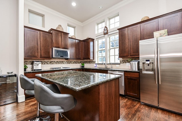 10924 Wrenwood Park, Houston, TX 77043 - kitchen featuring stainless steel appliances, a kitchen island, crown molding, dark brown cabinetry, and decorative backsplash