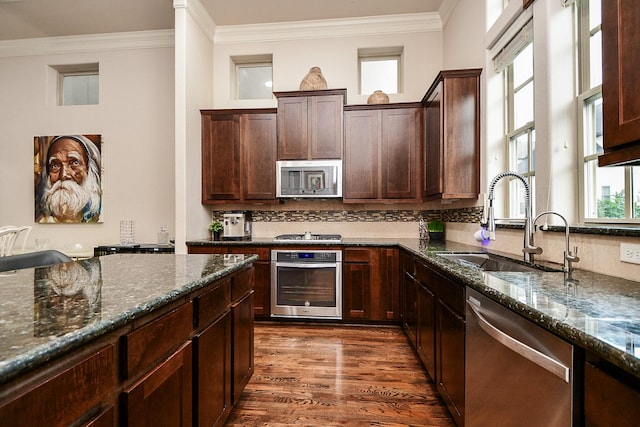 10924 Wrenwood Park, Houston, TX 77043 - kitchen featuring stainless steel appliances, dark stone counters, dark wood-style floors, crown molding, and tasteful backsplash