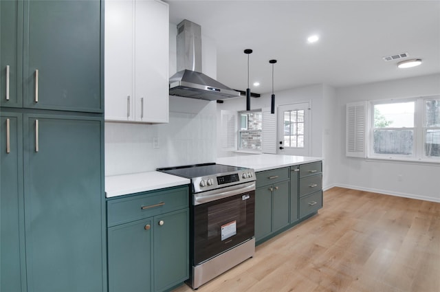 12706 Westleigh Dr, Houston, TX 77077 - kitchen with wall chimney range hood, electric stove, green cabinets, light wood-type flooring, and recessed lighting