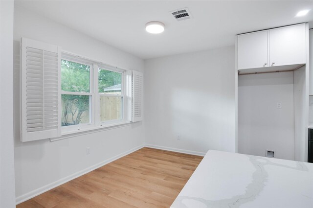 12706 Westleigh Dr, Houston, TX 77077 - unfurnished dining area with light wood-style flooring and baseboards