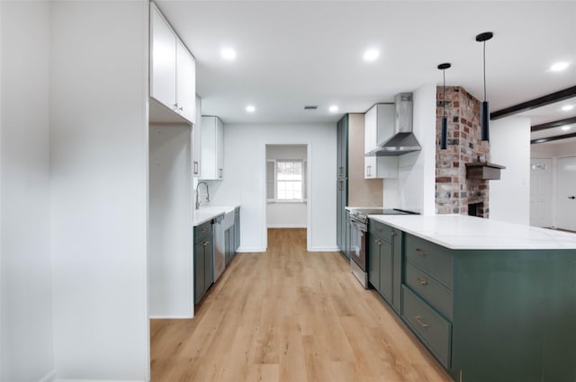 12706 Westleigh Dr, Houston, TX 77077 - kitchen with stainless steel appliances, wall chimney range hood, light countertops, light wood-type flooring, and white cabinets