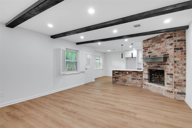 12706 Westleigh Dr, Houston, TX 77077 - unfurnished living room featuring light wood-style floors, beamed ceiling, a fireplace, and recessed lighting